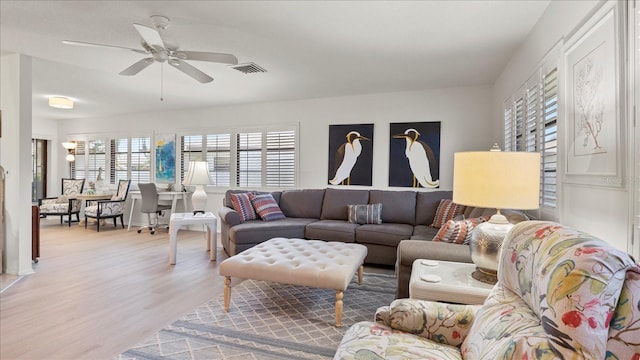 living room with light hardwood / wood-style floors and ceiling fan