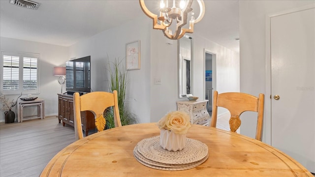 dining room featuring hardwood / wood-style floors and an inviting chandelier