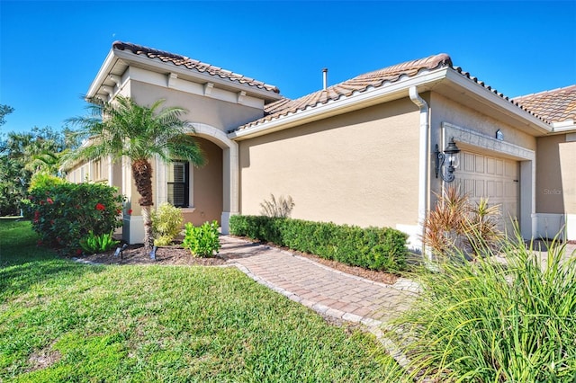 view of front of home featuring a front lawn and a garage