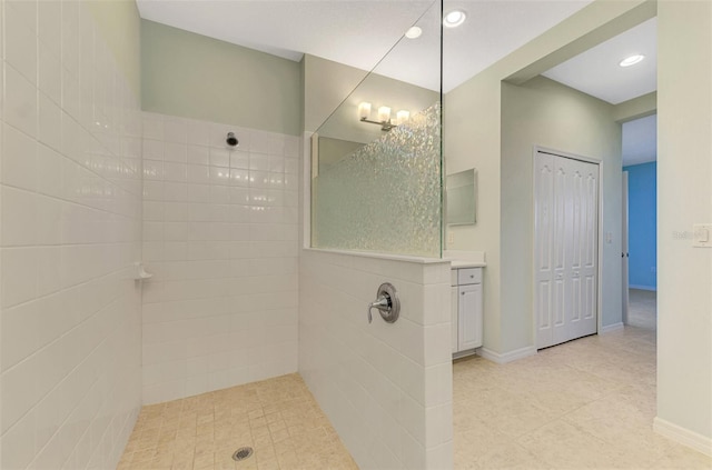 bathroom with tiled shower and vanity