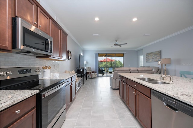 kitchen featuring ceiling fan, ornamental molding, sink, and appliances with stainless steel finishes