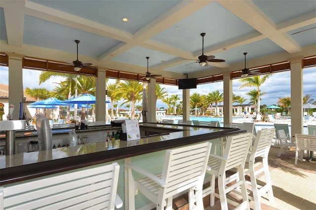 exterior space featuring ceiling fan, a water view, and an outdoor bar