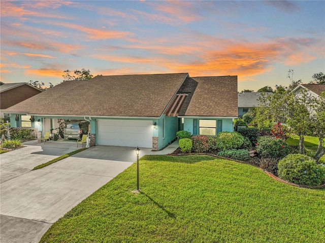 ranch-style house featuring a lawn and a garage