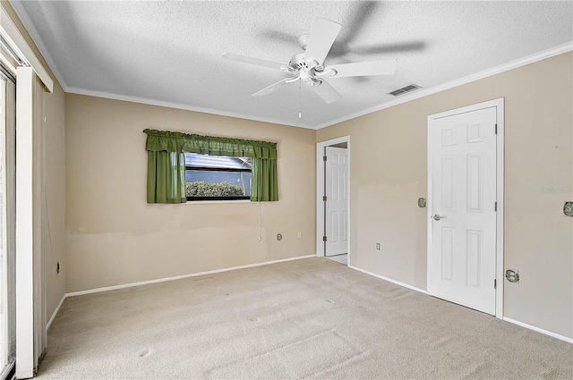 unfurnished bedroom featuring a textured ceiling, ceiling fan, crown molding, and light carpet