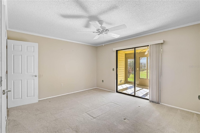 carpeted spare room with ceiling fan, ornamental molding, and a textured ceiling