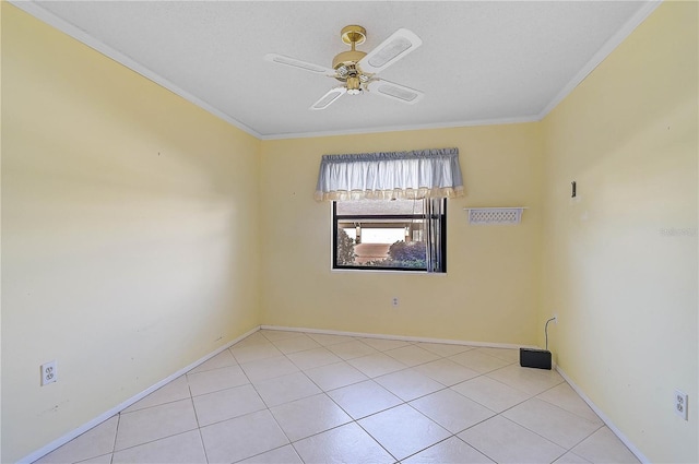 tiled empty room featuring ceiling fan and ornamental molding