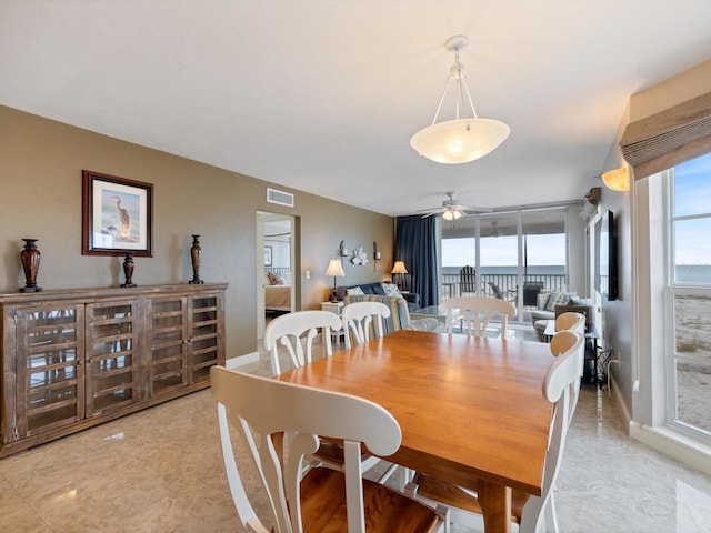 dining space featuring floor to ceiling windows and ceiling fan