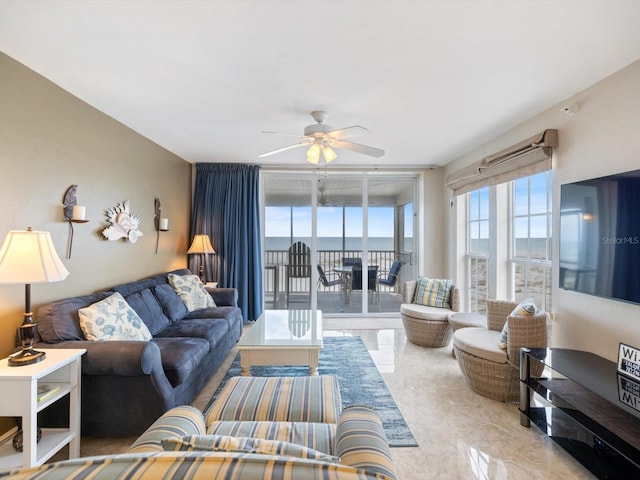 living room featuring ceiling fan and expansive windows