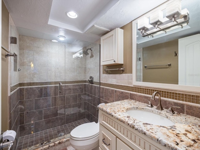 bathroom featuring an enclosed shower, vanity, toilet, and tile walls