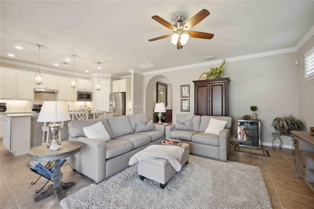 tiled living room featuring ceiling fan and crown molding