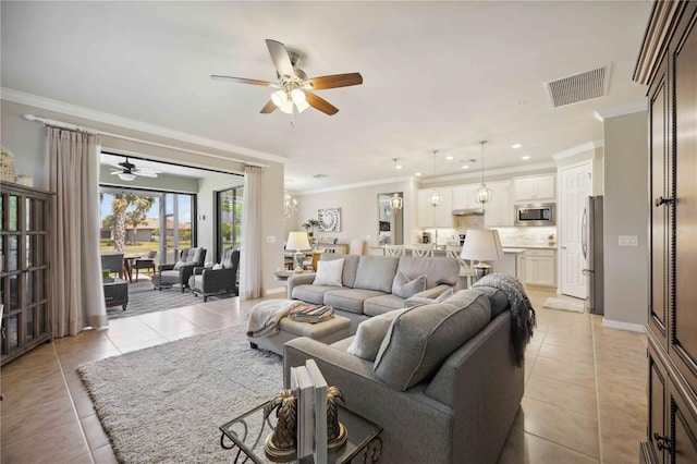 tiled living room with ceiling fan and crown molding