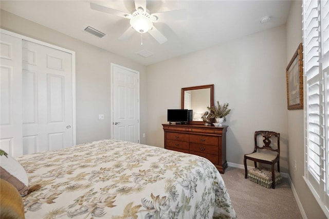 bedroom with ceiling fan, a closet, and light carpet