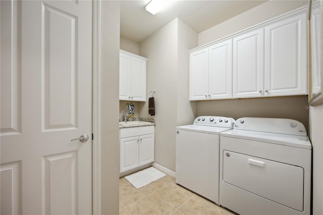 laundry area with cabinets, washing machine and dryer, sink, and light tile patterned flooring