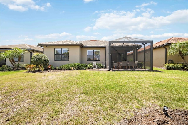 rear view of property featuring glass enclosure and a yard