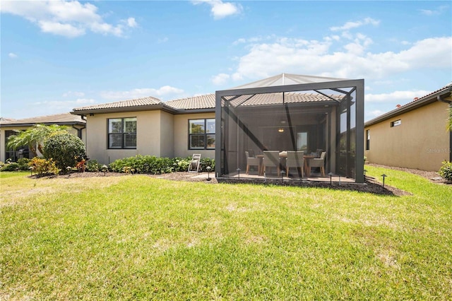 back of house featuring glass enclosure, a patio area, and a yard