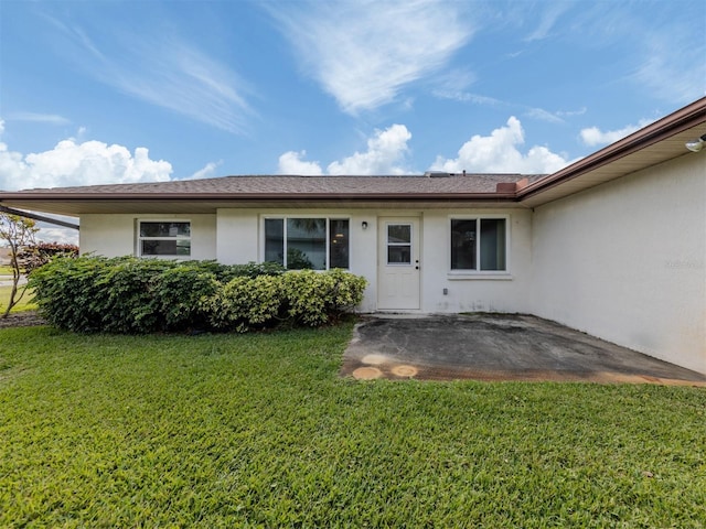 entrance to property with a yard and a patio