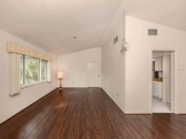 empty room featuring hardwood / wood-style flooring, lofted ceiling, and a textured ceiling