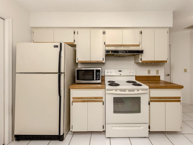 kitchen with a textured ceiling, light tile patterned flooring, and white appliances