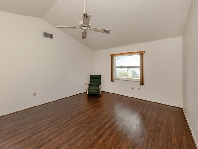 empty room featuring dark wood-type flooring, ceiling fan, and lofted ceiling