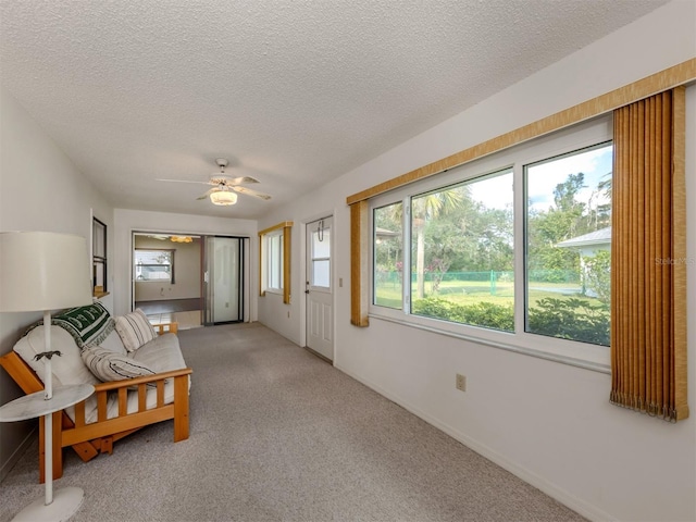 interior space with ceiling fan, carpet floors, and a textured ceiling