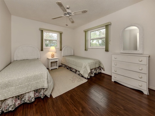 bedroom featuring multiple windows, ceiling fan, dark hardwood / wood-style flooring, and a textured ceiling