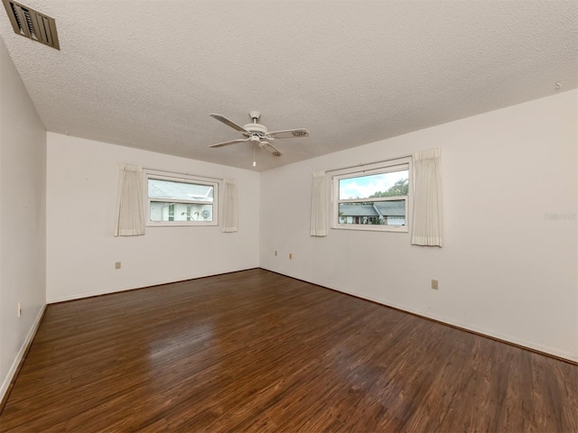 unfurnished room with ceiling fan, dark wood-type flooring, and a textured ceiling