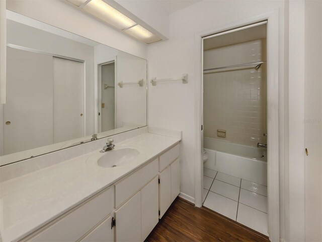 full bathroom featuring toilet, vanity, wood-type flooring, and tiled shower / bath