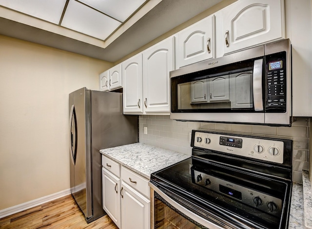 kitchen featuring decorative backsplash, appliances with stainless steel finishes, light hardwood / wood-style flooring, and white cabinetry