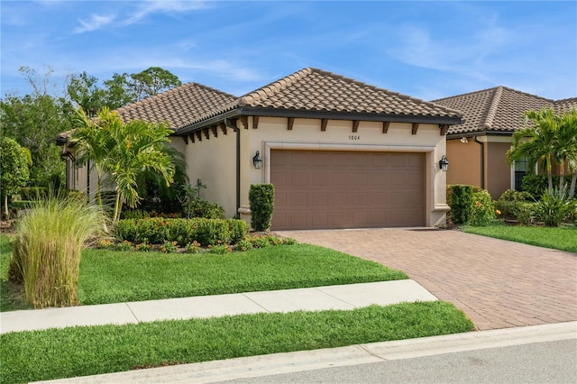 mediterranean / spanish home featuring a front lawn and a garage