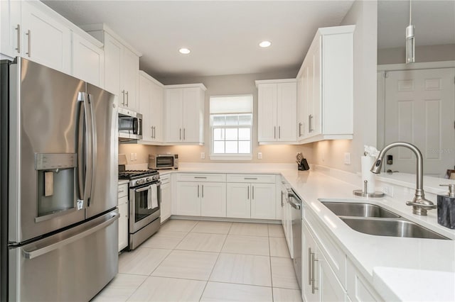 kitchen with sink, white cabinets, light tile patterned floors, and appliances with stainless steel finishes