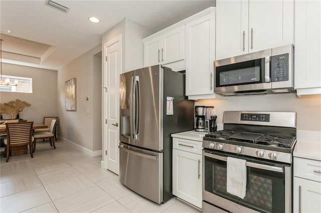 kitchen featuring stainless steel appliances, white cabinets, and light tile patterned floors