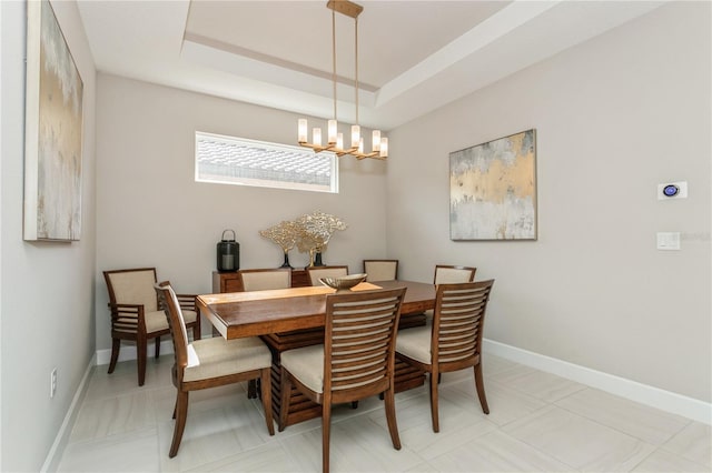 dining room featuring a raised ceiling and a notable chandelier