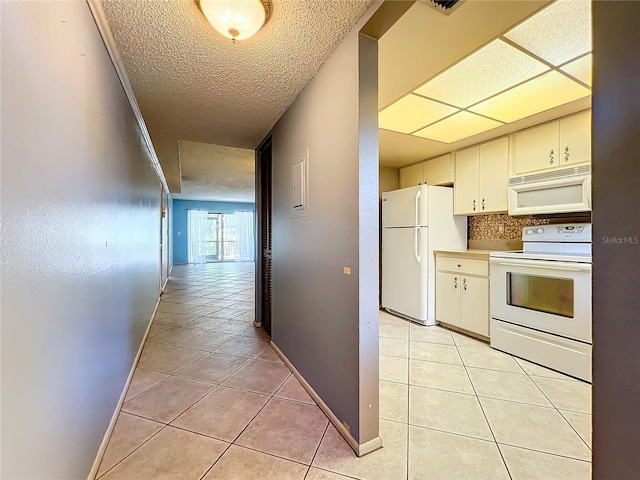 kitchen with light tile patterned flooring, white appliances, decorative backsplash, and a textured ceiling