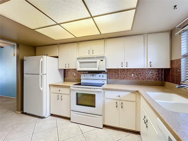 kitchen featuring sink, light tile patterned floors, white appliances, cream cabinetry, and backsplash