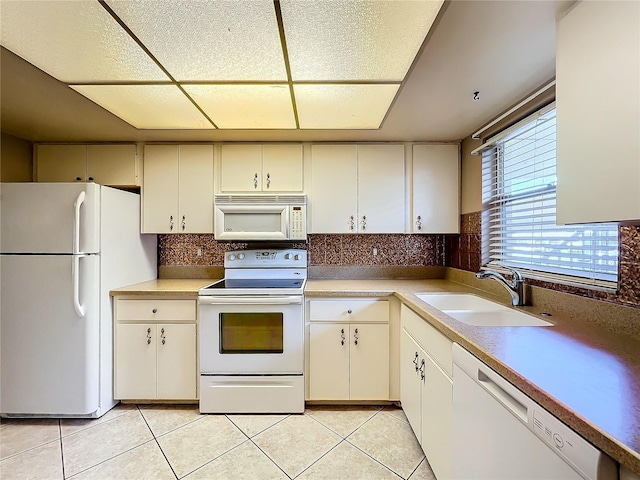 kitchen featuring sink, white appliances, tasteful backsplash, light tile patterned flooring, and cream cabinetry