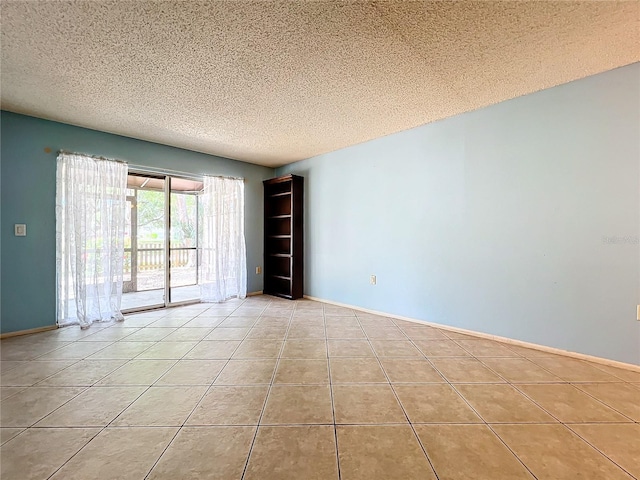 spare room with light tile patterned flooring and a textured ceiling