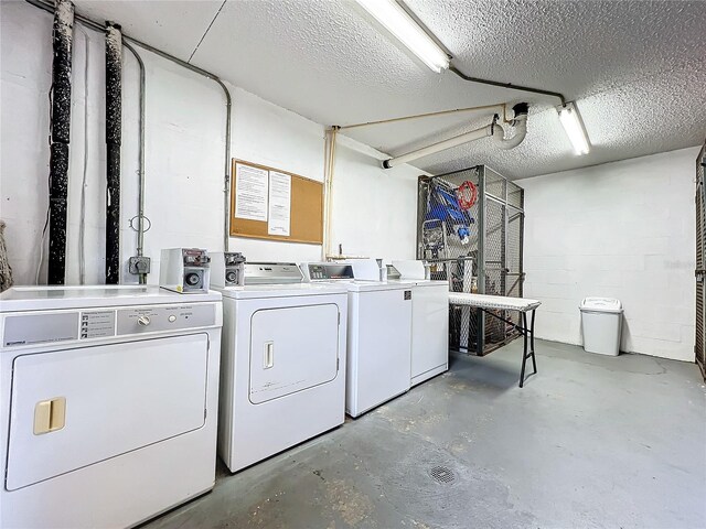 clothes washing area with washer and dryer and a textured ceiling