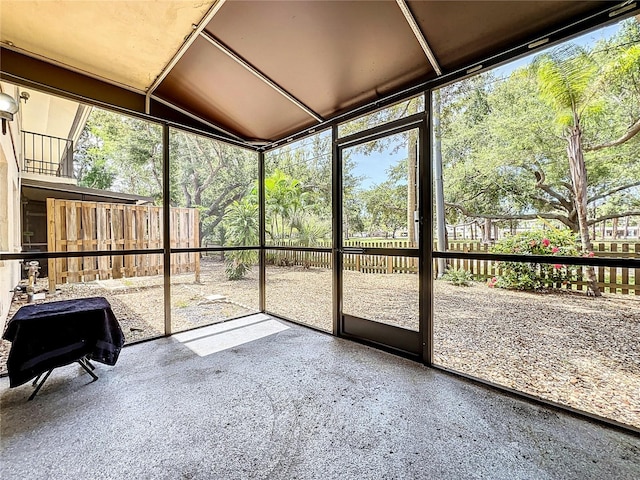 unfurnished sunroom featuring vaulted ceiling