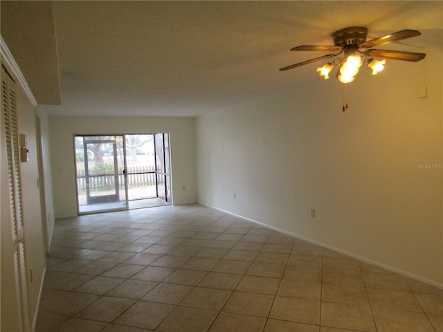 tiled spare room with ceiling fan