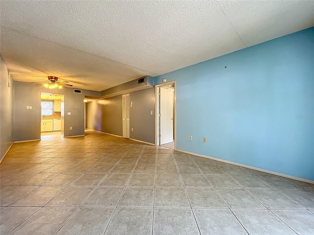 spare room with light tile patterned flooring, a textured ceiling, and ceiling fan