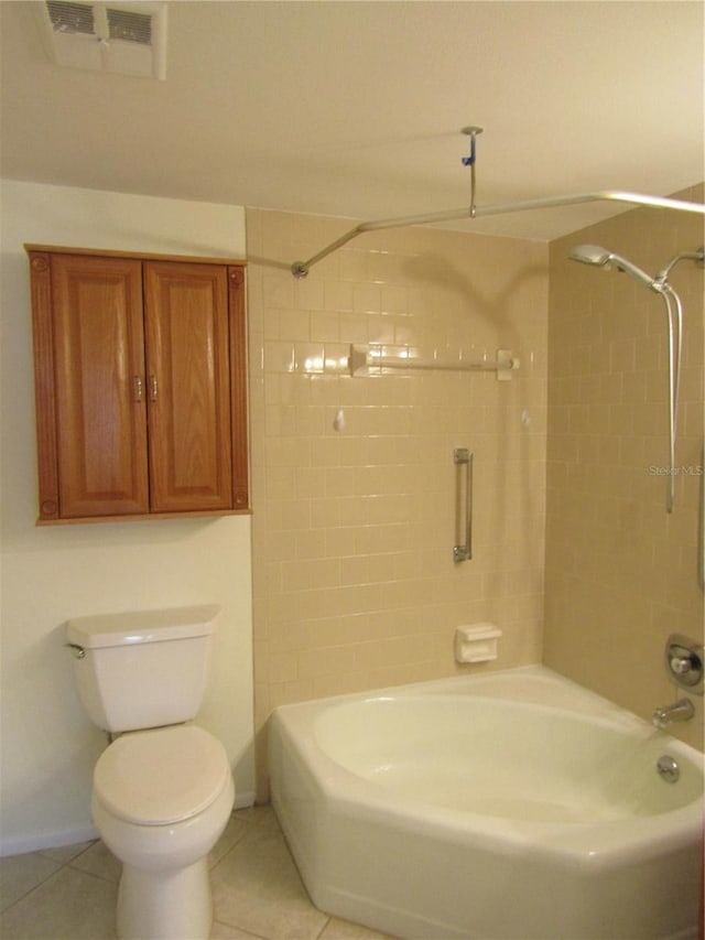 bathroom with tiled shower / bath, tile patterned floors, and toilet