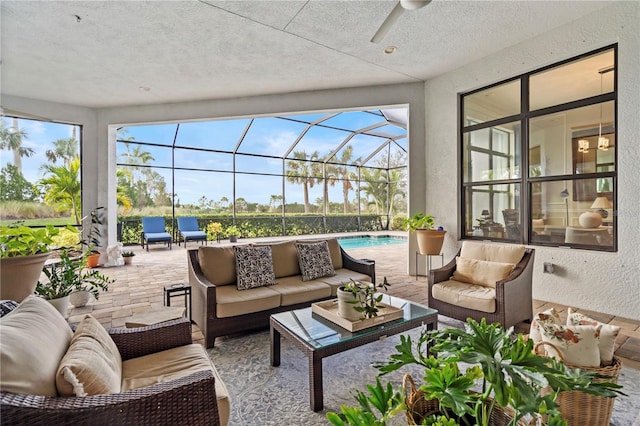 sunroom with ceiling fan and a pool