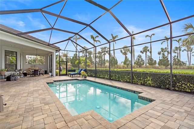 view of pool featuring ceiling fan, a patio area, and a lanai