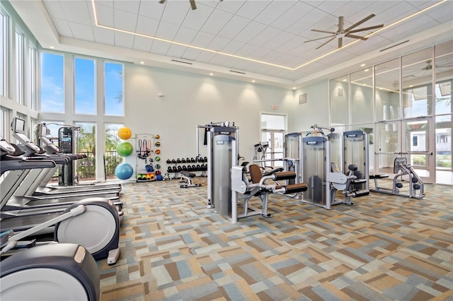 workout area featuring a wealth of natural light, ceiling fan, and a high ceiling