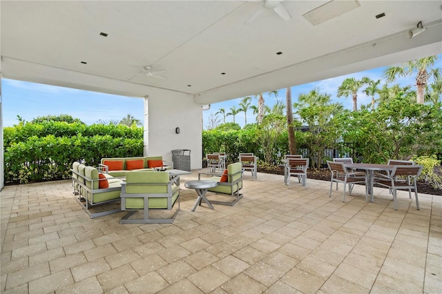 view of patio / terrace with an outdoor living space with a fireplace and ceiling fan