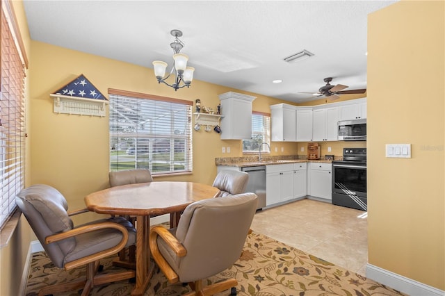 kitchen featuring white cabinets, ceiling fan with notable chandelier, light tile patterned floors, decorative light fixtures, and stainless steel appliances