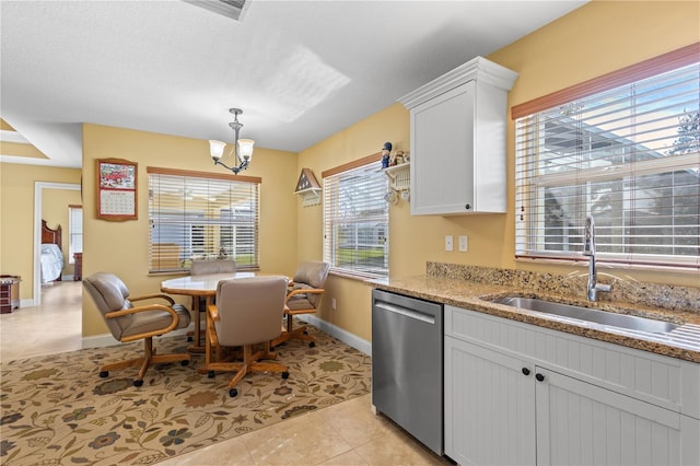 kitchen with sink, white cabinets, stainless steel dishwasher, a notable chandelier, and light tile patterned flooring