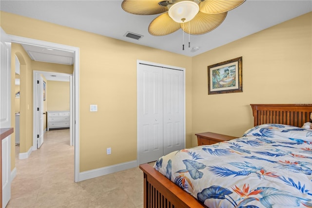 tiled bedroom with ceiling fan and a closet