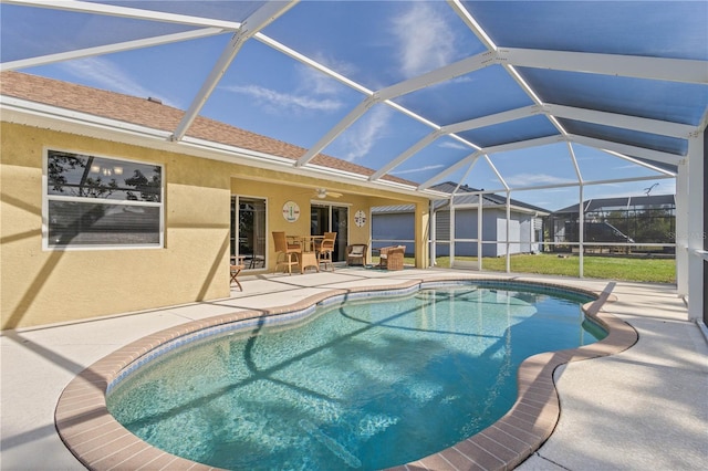 view of pool with a lanai, a patio area, and ceiling fan