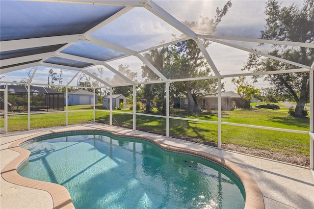 view of pool featuring a lawn, a patio area, a lanai, and a storage shed